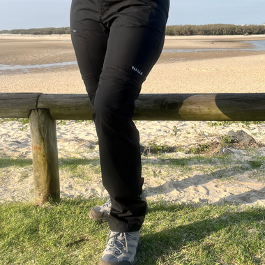 Woman wearing black hiking pants hiking on the beach