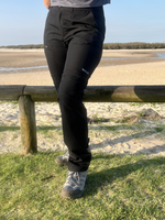 Woman wearing black hiking pants hiking on the beach