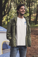 Man wearing a white t-shirt with the Nalle logo on camping in the forest