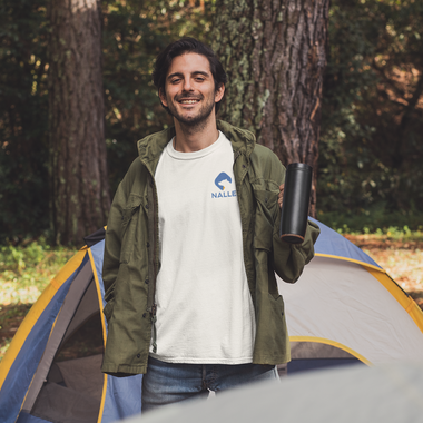 Man wearing a white t-shirt with the Nalle logo on camping in the forest