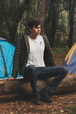 Man wearing a white t-shirt with the Nalle logo on camping in the forest